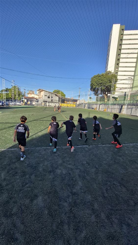 Alunos da Vasco Academy correndo em campo durante o aquecimento