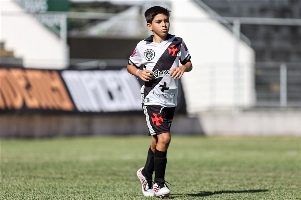 Aluno correndo em campo com a camisa branca e faixa preta