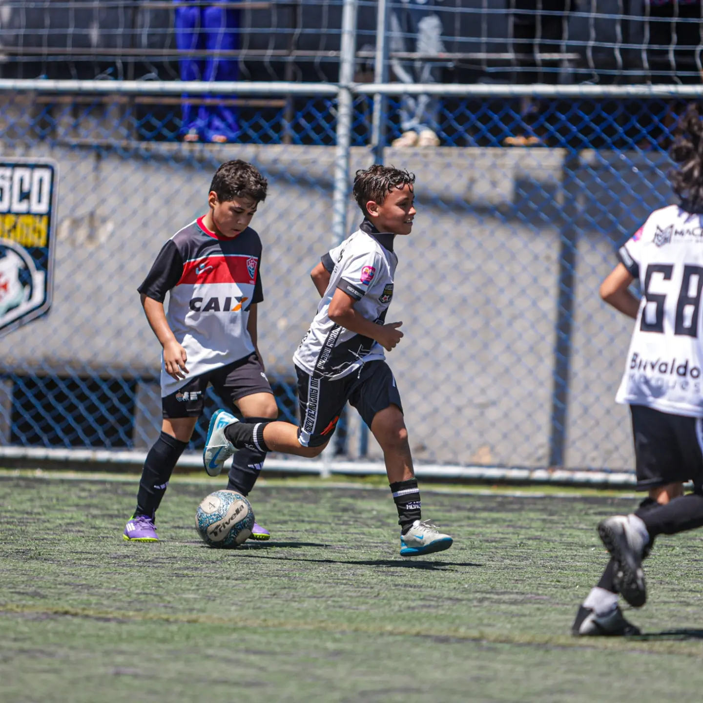 Aluno conduzindo a bola em velocidade durante o jogo