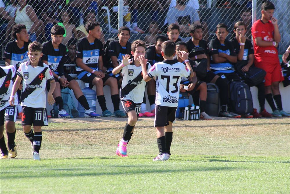 Dois alunos batendo as mãos para comemorar um gol
