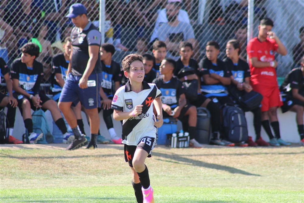 Aluno sorrindo enquanto corre em campo